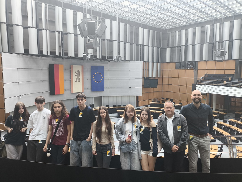 Uczniowie TME w sali plenarnej Abgeordnetenhaus pod flagami Niemiec, Berlina i Unii Europejskiej